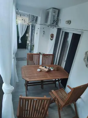 a porch with a wooden table and two chairs at Welcome to Voula in Athens