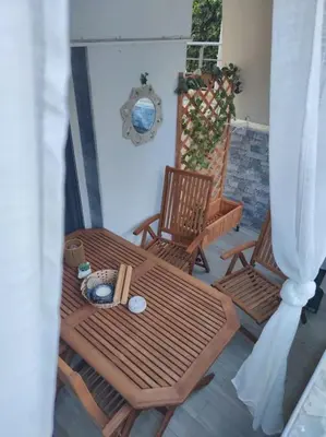 a patio with two chairs and a table and a wreath at Welcome to Voula in Athens