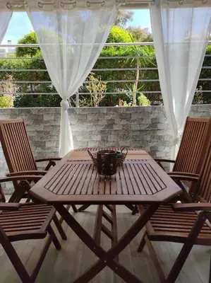 a wooden table and chairs on a patio at Welcome to Voula in Athens