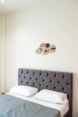 a bed with a gray headboard with two pillows at Vitsas House By Greece Apartments in Athens