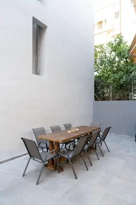 a wooden table and chairs on a patio at Vitsas House By Greece Apartments in Athens