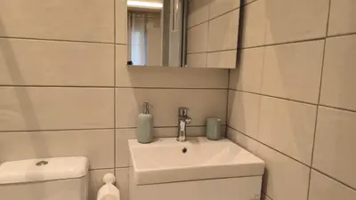 a bathroom with a sink and a toilet and a mirror at EstelZan Studio in Athens