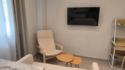 a living room with a chair and a television at EstelZan Studio in Athens