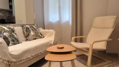 a living room with a white couch and a chair at EstelZan Studio in Athens