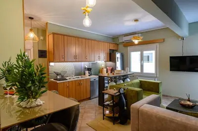 a living room with a couch and a kitchen at Voguish Design 2 bedroom Den in Athens