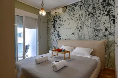 a bedroom with a large bed with a table on it at Voguish Design 2 bedroom Den in Athens