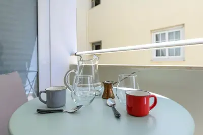 a table with two glasses and two cups and spoons at Voguish Design 2 bedroom Den in Athens