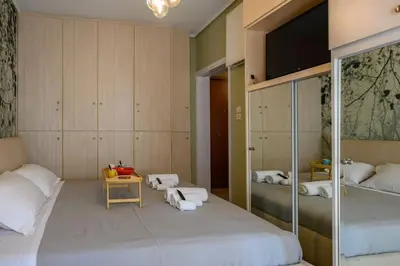 a bedroom with two beds and a tv in it at Voguish Design 2 bedroom Den in Athens