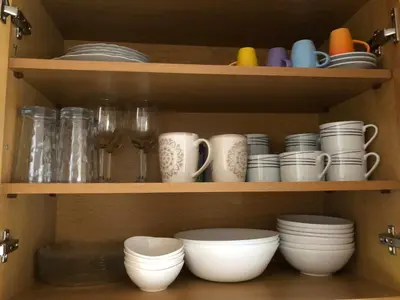 a shelf with dishes and cups and wine glasses at Seaview penthouse by the beach in Kalívia Thorikoú