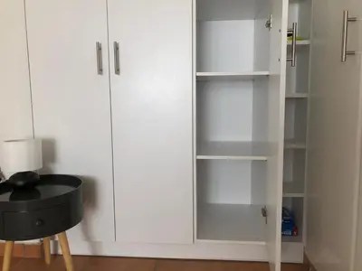 a white cabinet with glass shelves in a room at Seaview penthouse by the beach in Kalívia Thorikoú