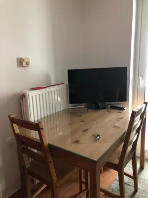 a wooden table with two chairs and a television at Seaview penthouse by the beach in Kalívia Thorikoú