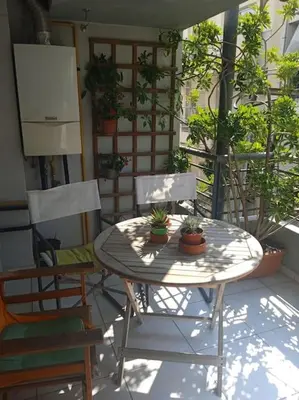 a table and chairs on a patio with plants at Georgia's house in Athens
