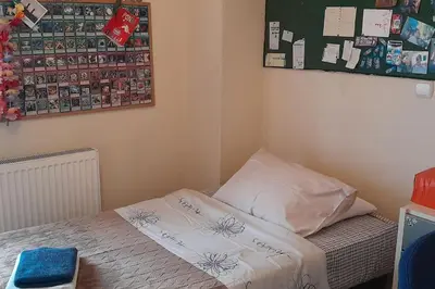 a small bedroom with a bed and a bulletin board at Georgia's house in Athens