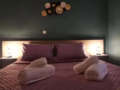 a bedroom with two towels on a bed with two lamps at Mary's Apartment, Athens Zografou in Athens
