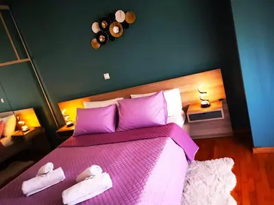 a bedroom with a pink bed with two towels on it at Mary's Apartment, Athens Zografou in Athens