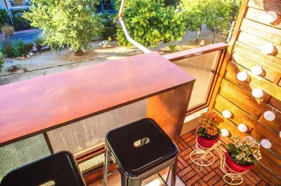 a balcony with a wooden table and two stools at Mary's Apartment, Athens Zografou in Athens