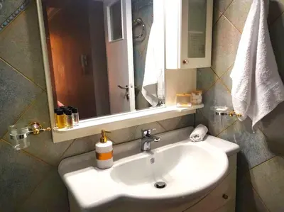 a white sink in a bathroom with a mirror at Mary's Apartment, Athens Zografou in Athens