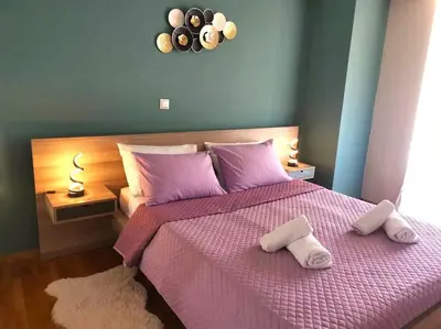 a bedroom with a pink bed with two towels on it at Mary's Apartment, Athens Zografou in Athens