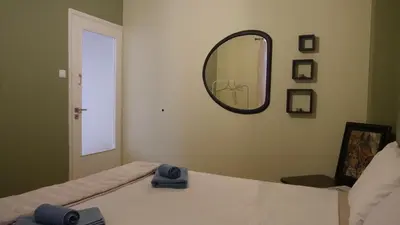a bedroom with a mirror on the wall and a bed at Classic Athenian house 2mins from metro in Athens