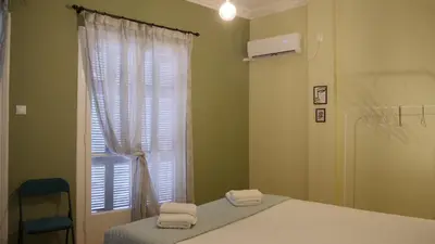 a bedroom with a bed and a window with towels at Classic Athenian house 2mins from metro in Athens