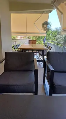 a living room with a table and two couches and a table at quiet apartment near the sea in Athens
