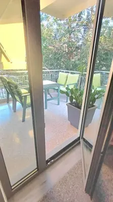 a sliding glass door of a patio with a bench at quiet apartment near the sea in Athens