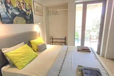 a bedroom with a large bed with yellow pillows at quiet apartment near the sea in Athens