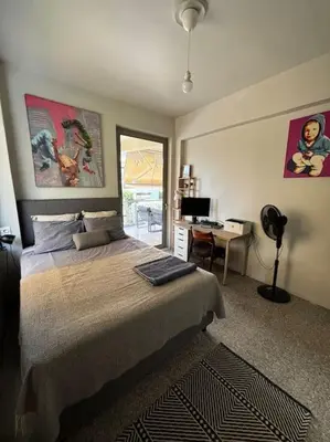a bedroom with a bed and a desk with a computer at quiet apartment near the sea in Athens