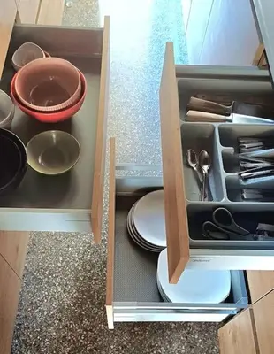 a cabinet with dishes and utensils in it at quiet apartment near the sea in Athens