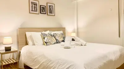 a bedroom with a large white bed with two lamps at Kostas Athens Residence in Athens