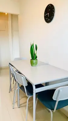 a dining room table with chairs and a clock on the wall at Kostas Athens Residence in Athens