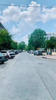 an empty street with cars parked in a parking lot at Kostas Athens Residence in Athens