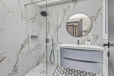 a bathroom with a shower and a sink and a mirror at City Vibes Kolonaki in Athens