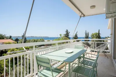 a patio with a table and chairs on a balcony at Athens Riviera 2BR Luxury Apartment in Athens