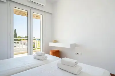 a white bedroom with a bed with towels on it at Athens Riviera 2BR Luxury Apartment in Athens