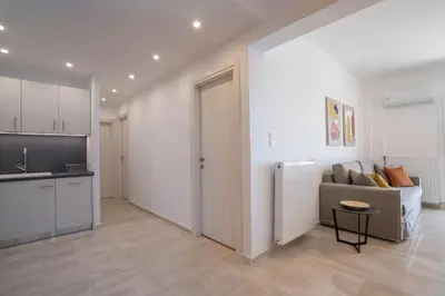 a living room with a couch and a kitchen at Athens Riviera 2BR Luxury Apartment in Athens