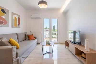 a living room with a couch and a television at Athens Riviera 2BR Luxury Apartment in Athens