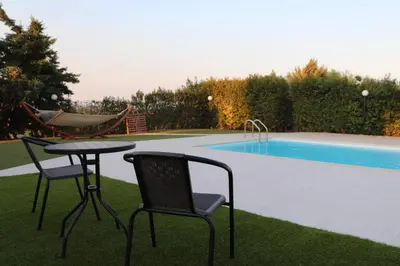 a table and chairs next to a swimming pool at Country house for4 in Markopoulo
