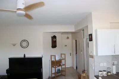 a living room with a ceiling fan and a clock at Country house for4 in Markopoulo
