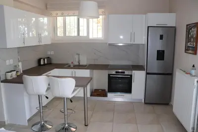 a kitchen with white appliances and white cabinets at Country house for4 in Markopoulo