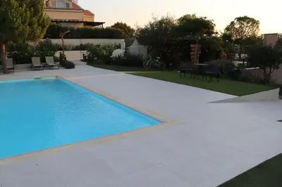 a swimming pool in a yard with a table and chairs at Country house for4 in Markopoulo