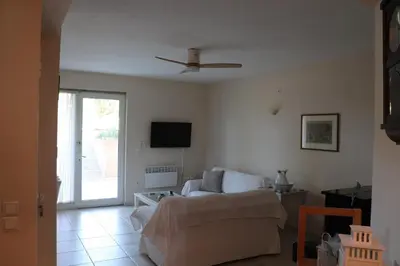 a living room with a couch and a ceiling fan at Country house for4 in Markopoulo