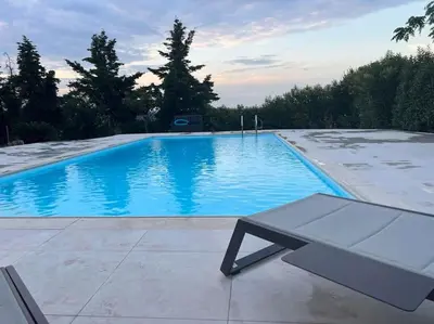 a swimming pool with a bench in front of it at Country house for4 in Markopoulo