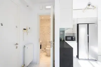 a white kitchen with a toilet and a sink at Elegant Coastal Haven Fully Renovated 3-Bedroom Apartment in Athens