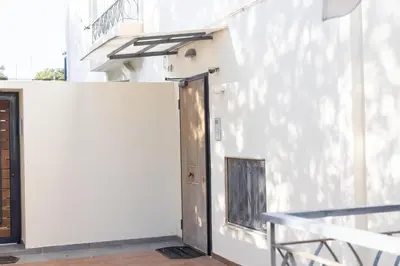 a door in the side of a white building at Elegant Coastal Haven Fully Renovated 3-Bedroom Apartment in Athens