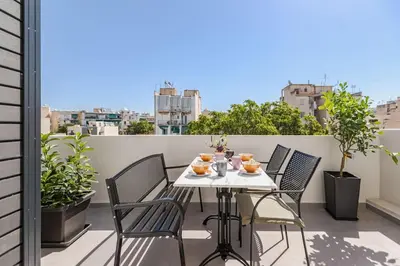 a table and chairs on a balcony with a view at The Meta Stay -Rooftop Access Sunny 2bdr Apartment in Athens