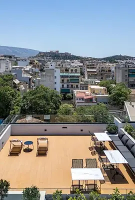 a balcony with tables and chairs and a city at The Meta Stay -Rooftop Access Sunny 2bdr Apartment in Athens