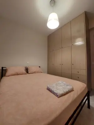 a bedroom with a large bed and a large cabinet at Gabi's Apartment in Porto Rafti