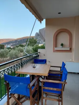 a table and chairs on the balcony of a house at Gabi's Apartment in Porto Rafti