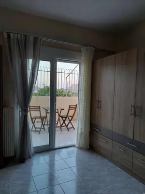 a living room with a table and chairs and a window at Gabi's Apartment in Porto Rafti